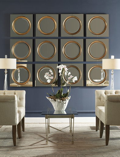 12 small square mirrors with gold circle feature on each mirror hanging together on a blue wall